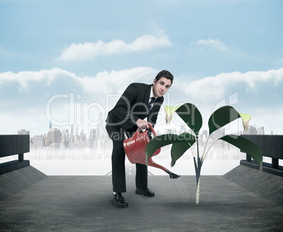 Composite image of businessman watering with red can