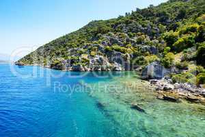 Ruins on on the shores of Kekova Island and yacht with tourists,