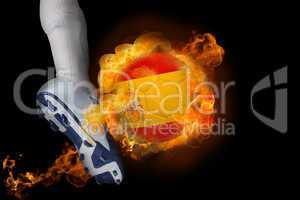 Football player kicking flaming spain ball