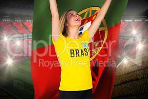 Excited football fan in brasil tshirt holding portugal flag
