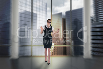 Composite image of redhead businesswoman in a blindfold