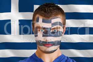 Serious young greece fan with facepaint