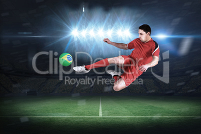 Fit football player jumping and kicking