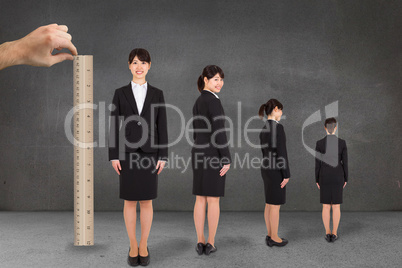 Composite image of hand measuring businesswoman with ruler