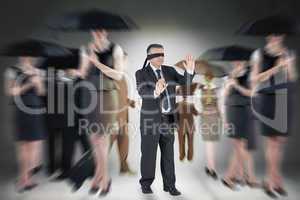 Composite image of mature businessman in a blindfold