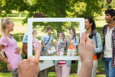 Composite image of hand holding tablet pc