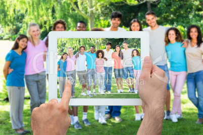 Composite image of hand holding tablet pc