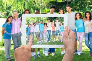 Composite image of hand holding tablet pc