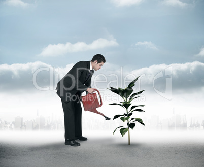 Composite image of businessman watering with red can