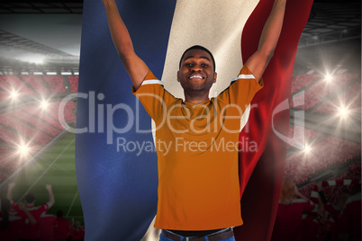 Cheering football fan in orange jersey holding netherlands flag