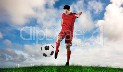 Composite image of football player in red kicking