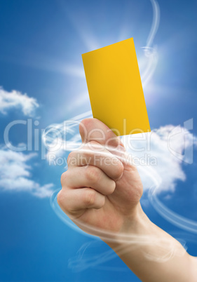 Composite image of hand holding up yellow card