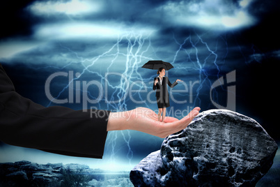 Composite image of young businesswoman holding umbrella in large