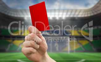 Composite image of hand holding up red card