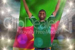 Composite image of cheering football fan in green jersey holding