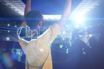 Composite image of cheering football fan in yellow jersey