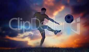 Composite image of football player in yellow kicking