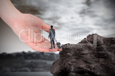 Composite image of young businessman standing with suitcase on l