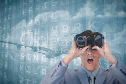 Composite image of suprised businessman looking through binocula