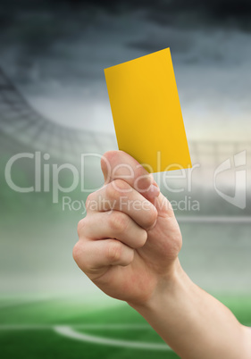 Composite image of hand holding up yellow card