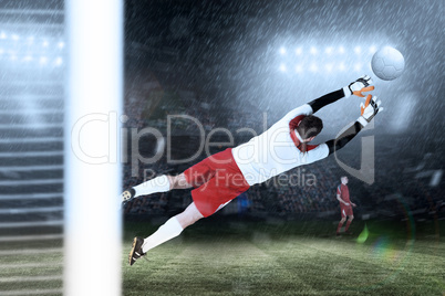 Composite image of goalkeeper in white jumping up