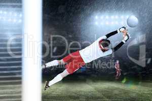 Composite image of goalkeeper in white jumping up