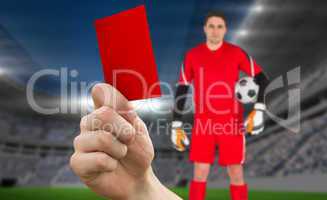 Composite image of hand holding up red card to goalie