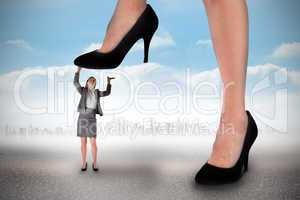 Composite image of businesswoman stepping on tiny businesswoman