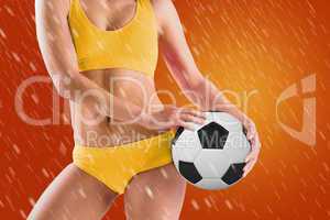 Composite image of fit girl in yellow bikini holding football