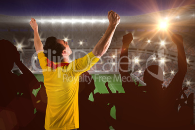 Composite image of cheering football fan in yellow jersey