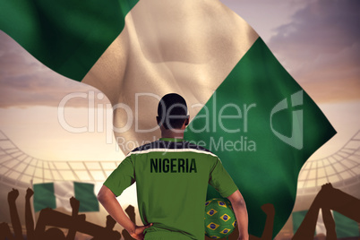 Composite image of nigeria football player holding ball