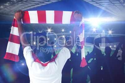 Composite image of happy football fan waving scarf