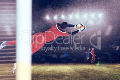 Composite image of goalkeeper in red making a save