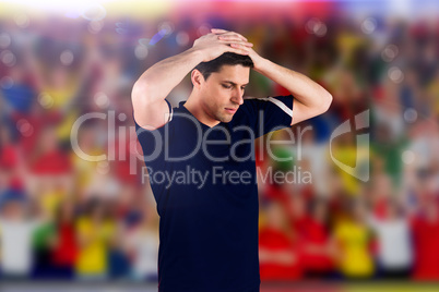 Composite image of disappointed football player looking down