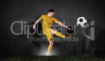 Composite image of football player in yellow kicking