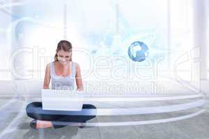 Composite image of cross legged woman using a laptop