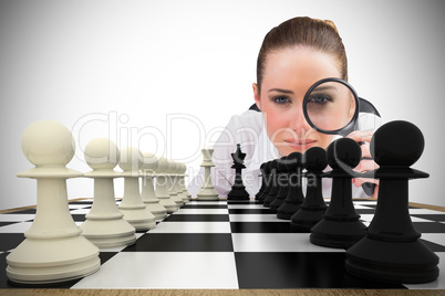 Composite image of thinking businesswoman with magnifying glass