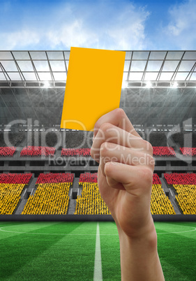 Composite image of hand holding up yellow card