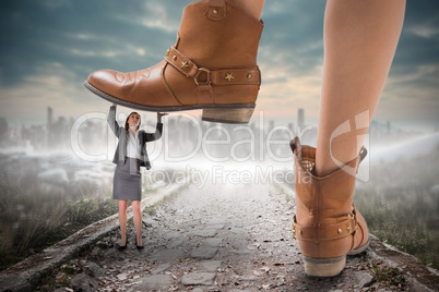 Composite image of cowboy boots stepping on businesswoman