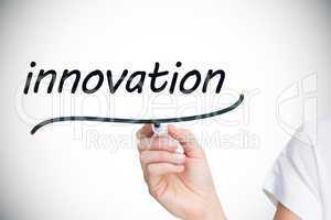 Businesswoman writing the word innovation