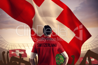 Composite image of swiss football player holding ball