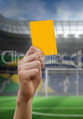 Composite image of hand holding up yellow card