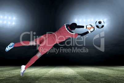 Composite image of goalkeeper in red making a save