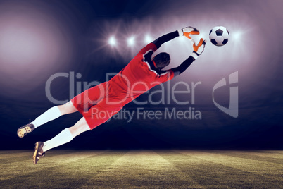 Composite image of goalkeeper in red jumping up