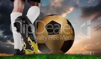 Composite image of football boot kicking huge gold ball
