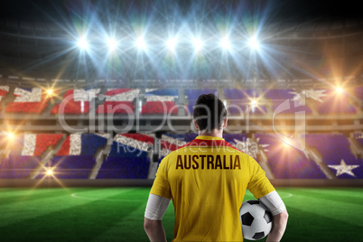 Composite image of australia football player holding ball