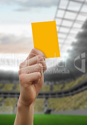 Composite image of hand holding up yellow card