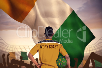 Composite image of ivory coast football player holding ball
