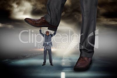 Composite image of businessman stepping on tiny businessman