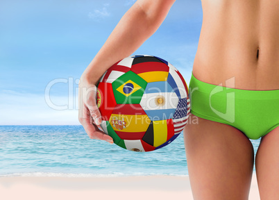 Composite image of fit girl in green bikini holding flag footbal